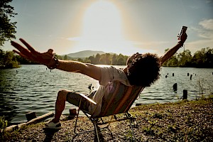 Florian Geiss, a London photographer with Horton-Stephens, captures lifestyle images of people having fun outdoors, drinking natural and authentic drinks.photography agency london. Man relaxing by lake.