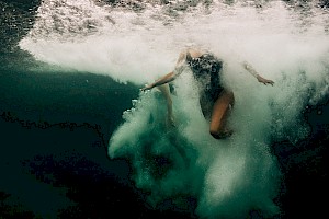 This colour photo shows models underwater in the sea by James Bowden, UK  photographer, represented by Horton-Stephens photographer’s agents specialises in natural and authentic  lifestyle outdoors nature photographic images.