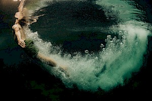 This colour photo shows models diving into the sea by James Bowden, UK  photographer, represented by Horton-Stephens photographer’s agents specialises in natural and authentic  lifestyle outdoors nature photographic images.