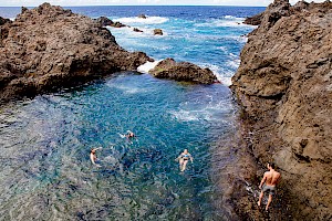 This colour photo shows swimming models in the landscape outdoors  by James Bowden, UK  photographer, represented by Horton-Stephens photographer’s agents specialises in natural and authentic  lifestyle outdoors nature photographic images.