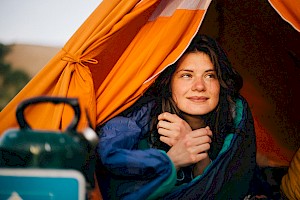 This colour photo shows a model camping by James Bowden, UK  photographer, represented by Horton-Stephens photographer’s agents specialises in natural and authentic  lifestyle outdoors nature photographic images.