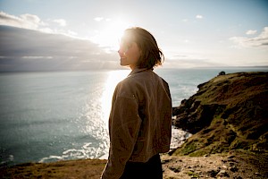 ames Bowden, UK  photographer, represented by Horton-Stephens photographer’s agents specialises in natural and authentic  lifestyle outdoors nature photographic images, this colour photo shows a lady by the sea with a landscape