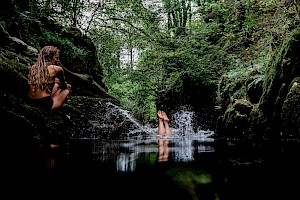 This colour photo shows models diving into lake for finisterre brand by James Bowden, UK  photographer, represented by Horton-Stephens photographer’s agents specialises in natural and authentic  lifestyle outdoors nature photographic images.