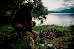This colour photo shows a camping lake expedition outdoors  by James Bowden, UK  photographer, represented by Horton-Stephens photographer’s agents specialises in natural and authentic  lifestyle outdoors nature photographic images.