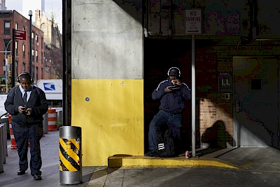 Man eating sandwich in a sunny carpark in New York photographed by Nick Dolding represented by London's top agency Horton-Stephens Photography