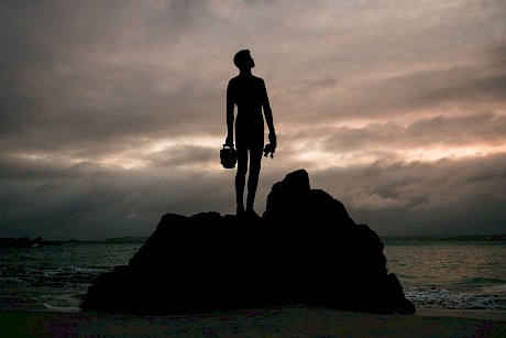 Man stands on rock shot by James Bowden top outdoor and lifestyle photographer represented by Horton Stephens agency