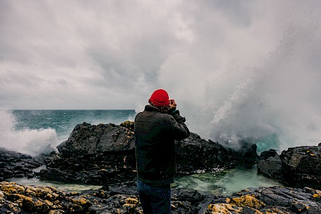 Man photogaphs crashing wave shot by James Bowden top outdoor and lifestyle photographer represented by Horton Stephens agency